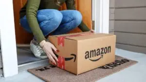 Mom picking up Amazon package filled with baby proofing products.