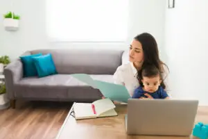 Mom with baby working on the computer in their living room