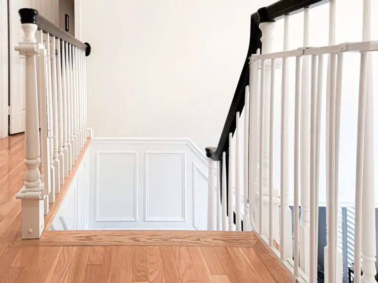 Elegant staircase with white railing and stairway gate laying flat against it