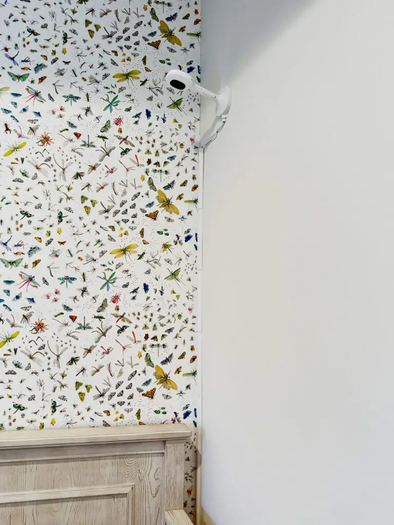 Close up photo of nanit baby monitor on wall of nursery next to crib.