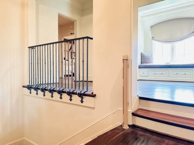 Elegant staircase with decorative railing and retractable gate