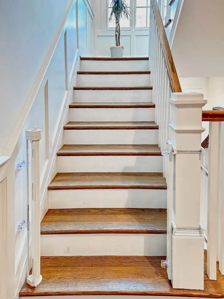 White retractable gate installed at bottom of the staircase in foyer.