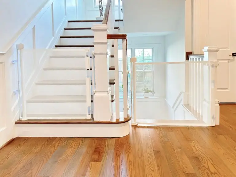 White retractable gates at the top and bottom of staircases in the foyer of a beautiful home.