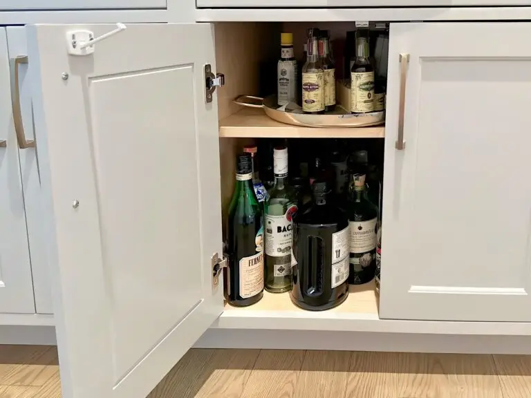 Cabinet latch and catch plate installed on cabinet with liquor.