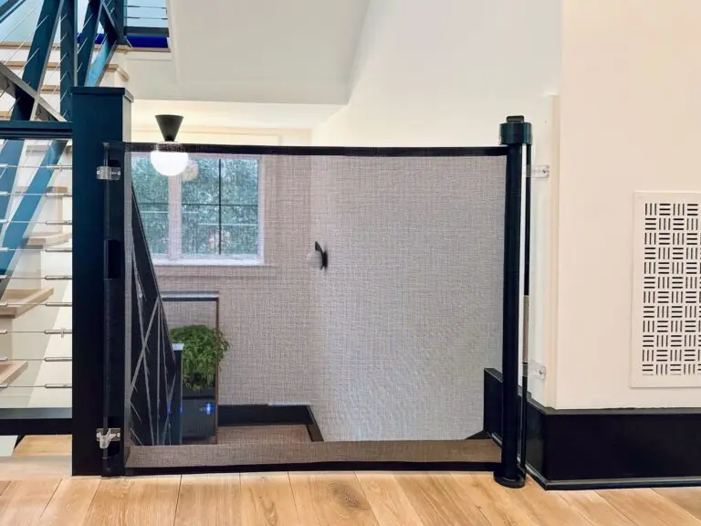 Black retractable gate in foyer on stairs going down.