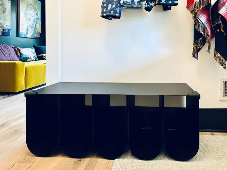 Modern black bench with corner cushions and storage compartments.