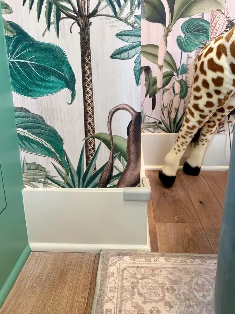 Giraffe figurine near tropical wallpaper with corner cushion