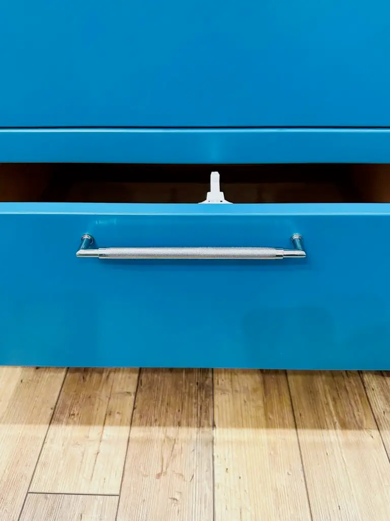Blue drawer with silver handle open and spring latch