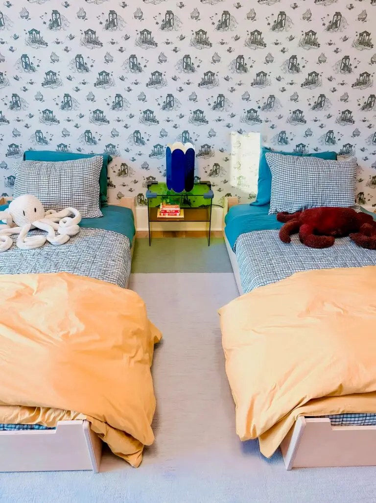 Two colorful beds with toys and corner cushion nightstand