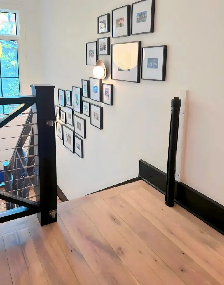 Modern staircase with framed photos and retractable gate
