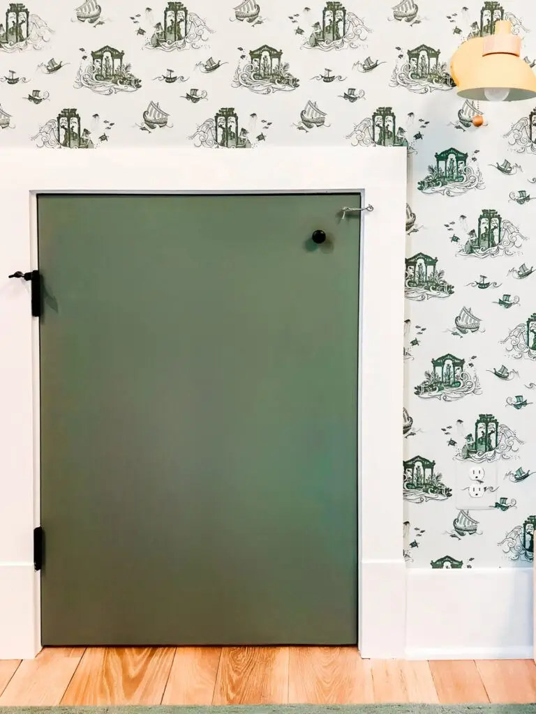 Small green door on patterned wall with spring hook and eye