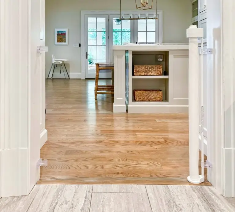 White retractable gate installed in kitchen door frame, open.