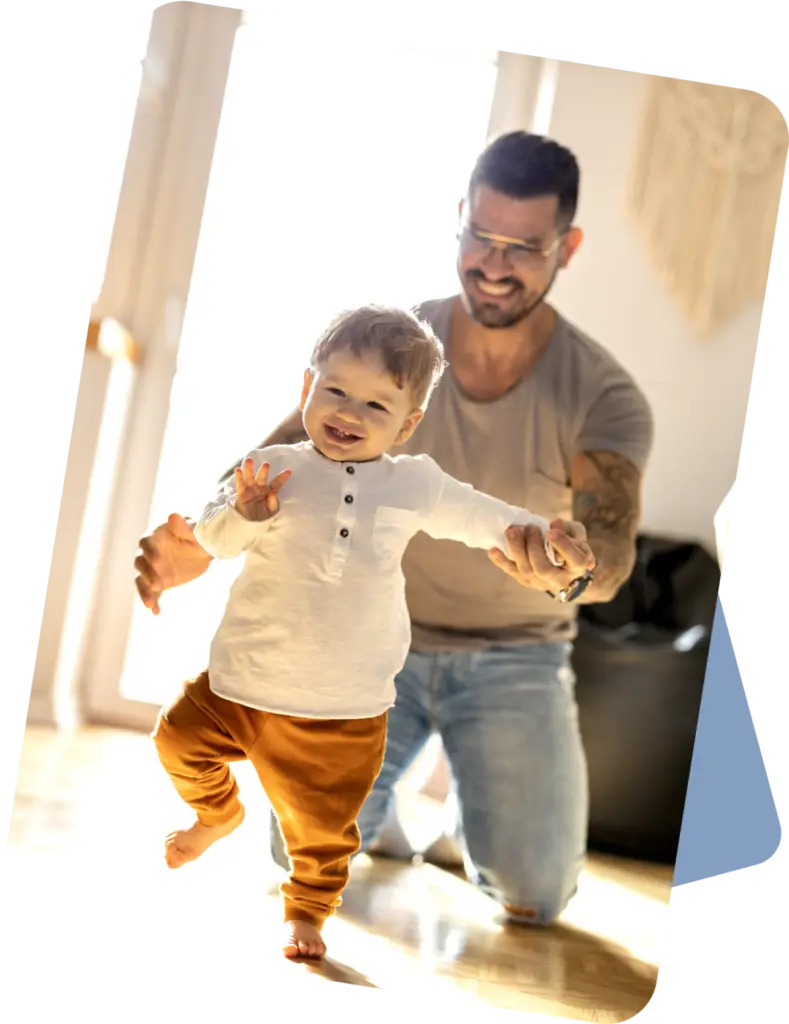 Dad watching baby taking steps and running around their home.