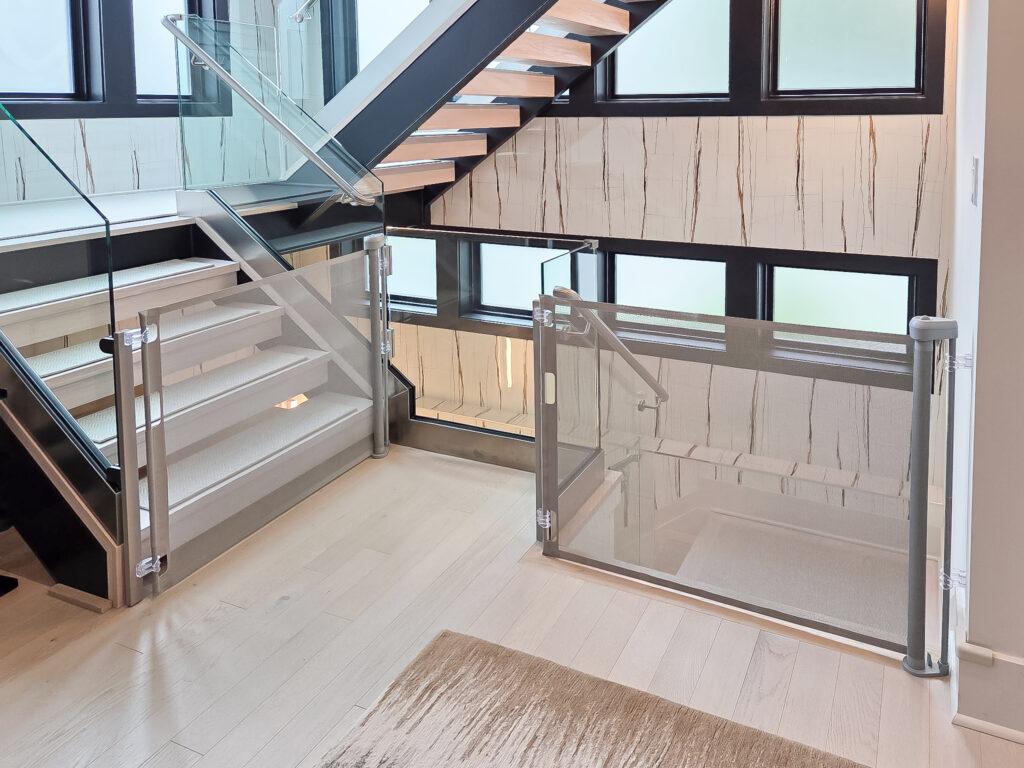 Gray retractable baby gates installed on staircases