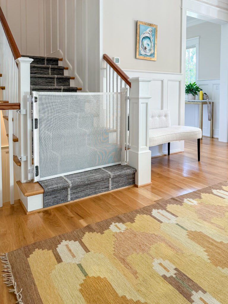 White retractable gate closed at the foot of the stairs beside the front hall in a bethesda, md home