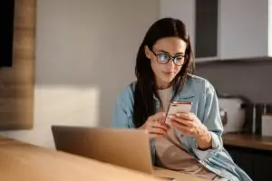 Mother looking at computer and deciding on professional baby proofing or diy