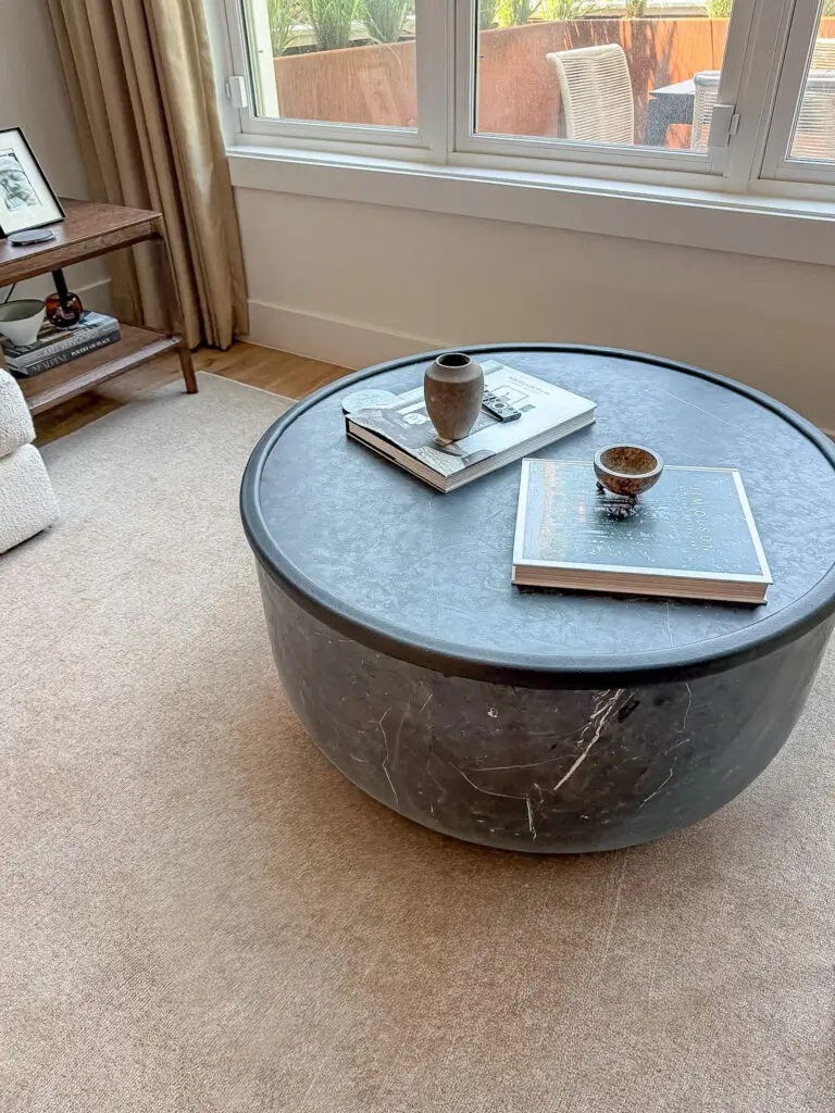 Black edge cushion on the stone edge of a round coffee table in a bethesda, md living room