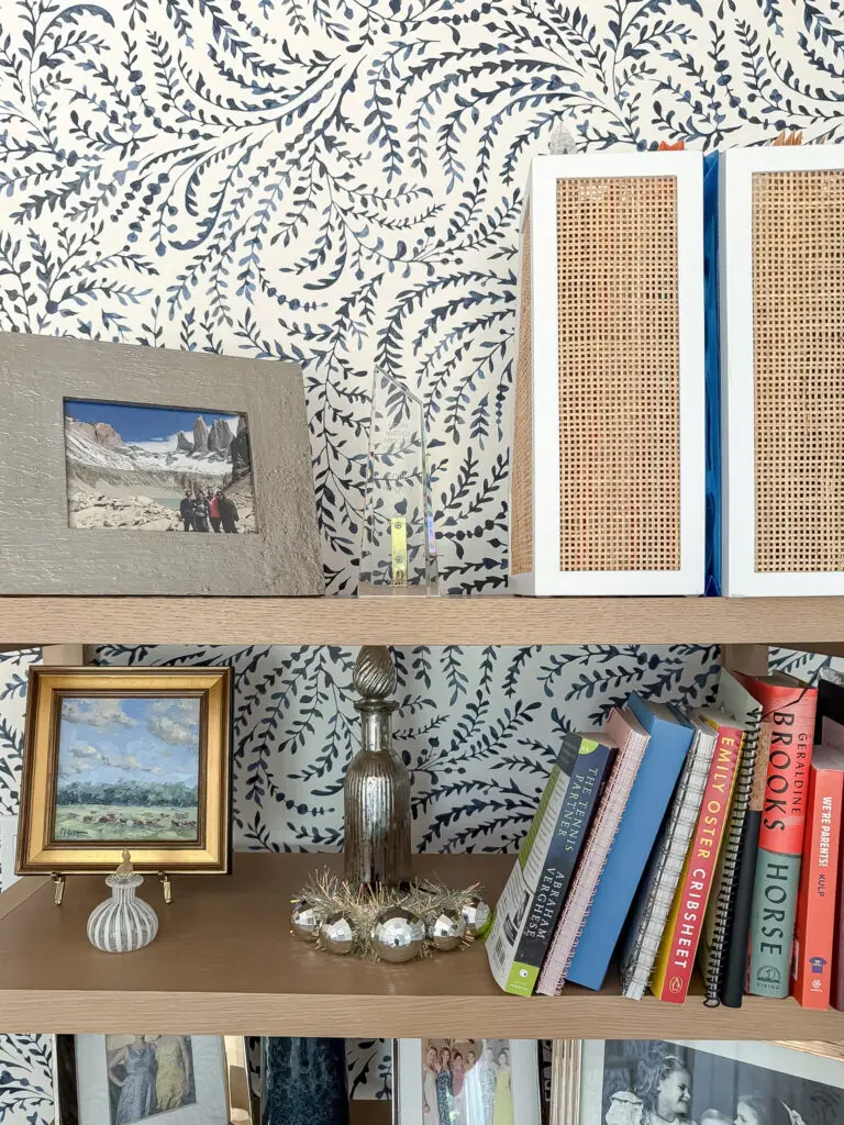 Anchored office shelving unit with books and framed photos
