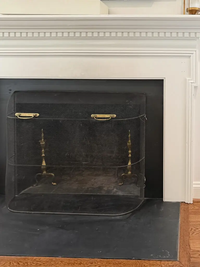 Fireplace screen anchored to the surrounding hearth so it cannot be pulled over