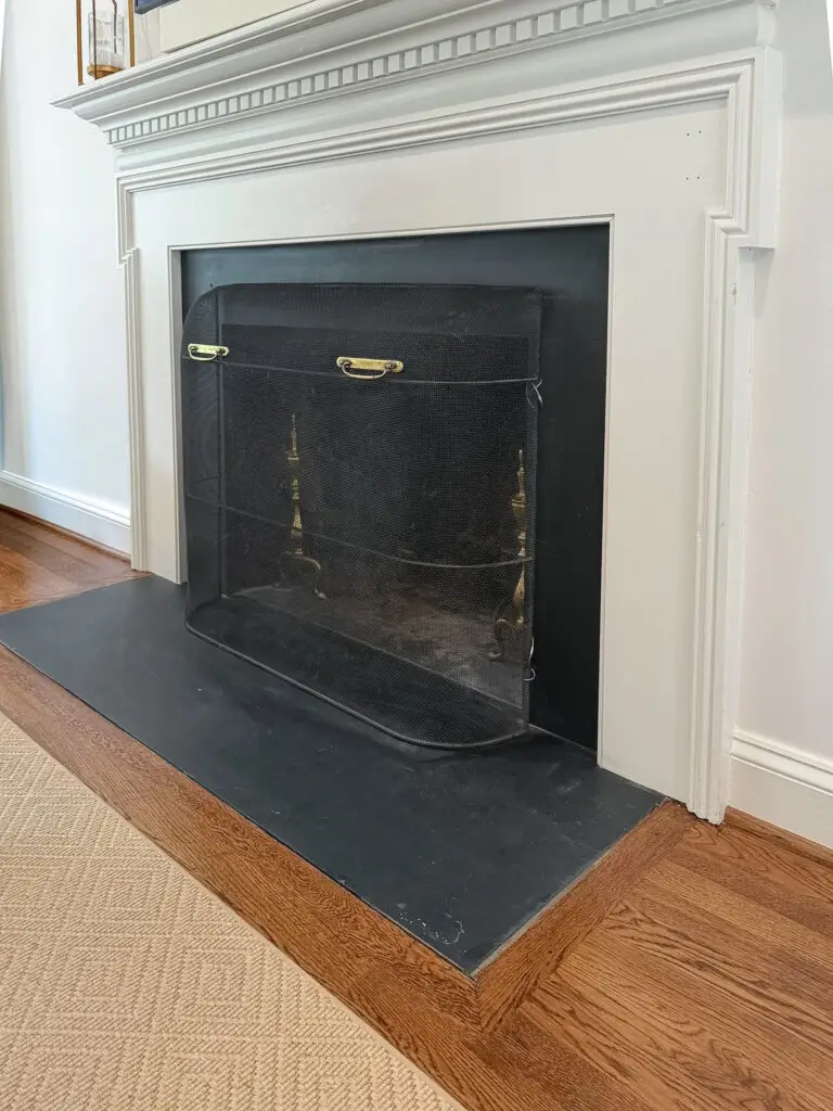 Anchored fireplace screen on a slate hearth in a bethesda, md living room
