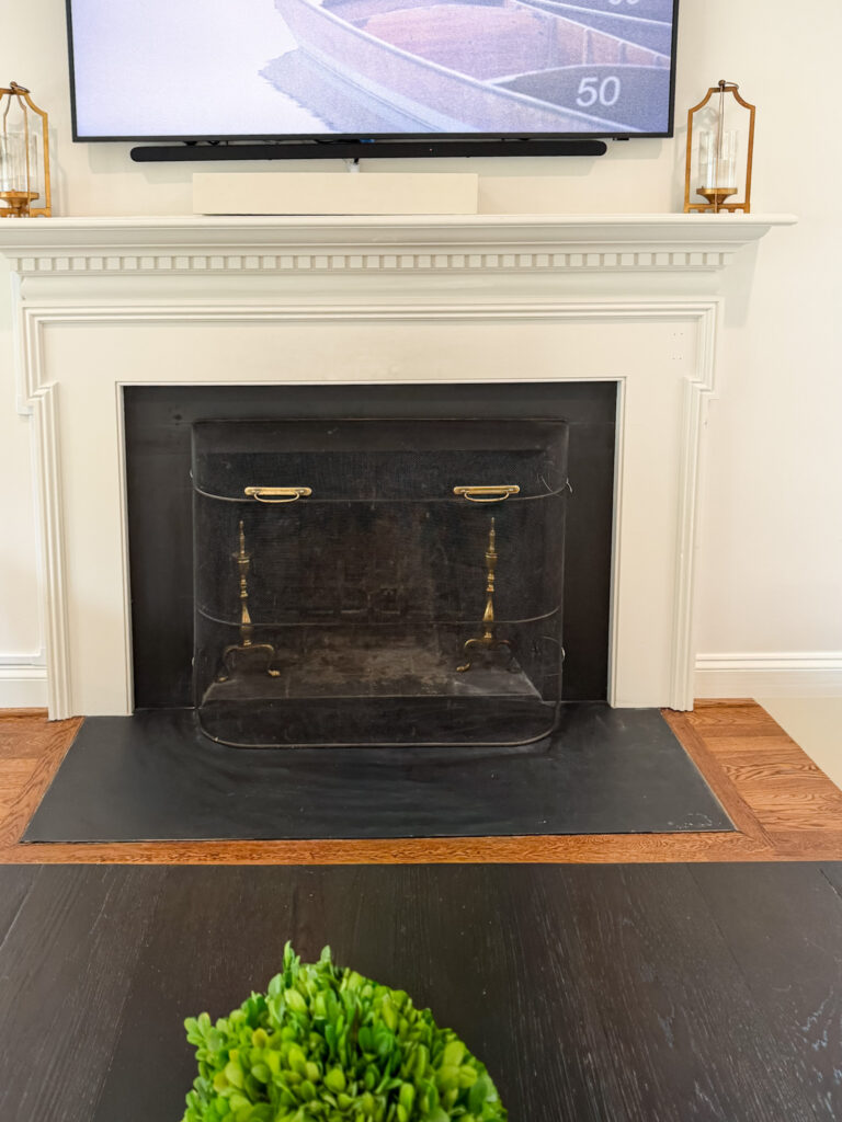 Living room fireplace with the safety screen anchored to the hearth beneath a wall-mounted tv in a bethesda, md home