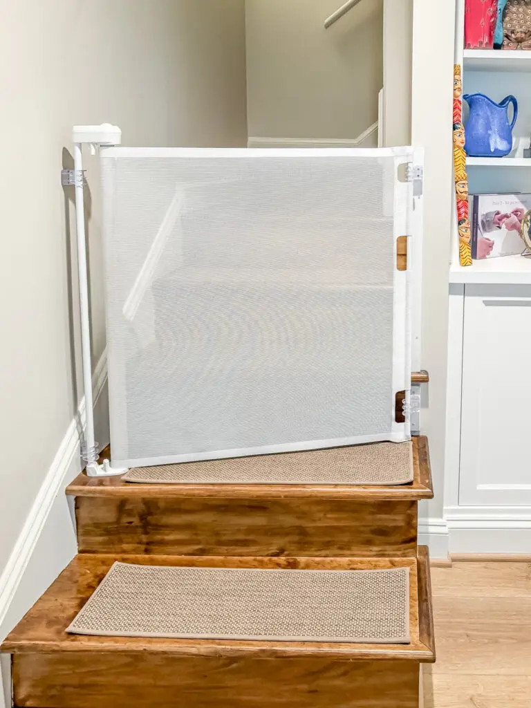 White retractable gate closed across the top of the basement stairs in a bethesda, md home
