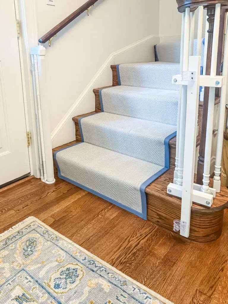 Retractable gate retracted at the foot of the stairs, showing the custom-stained post mounts