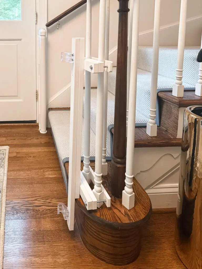 Close-up of custom-stained post mounts wrapping a turned newel post at the bottom of the stairs