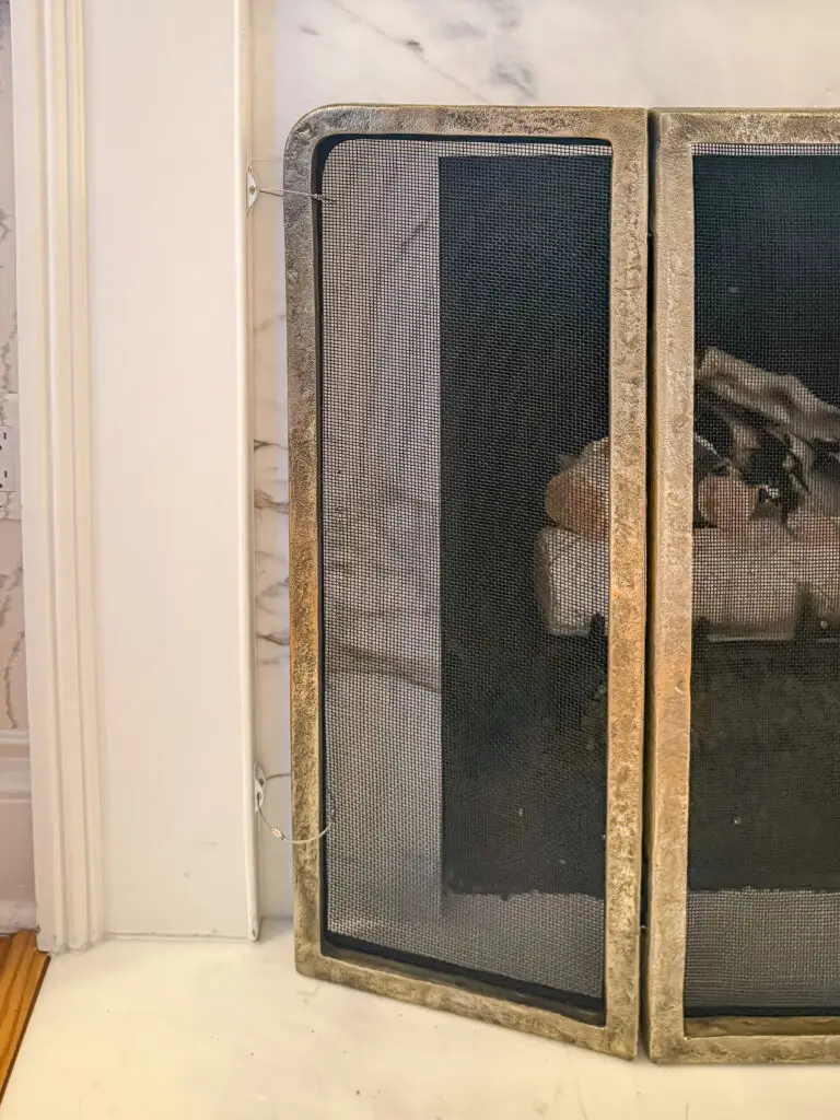 Close-up of the fireplace safety screen anchored to the fireplace surround