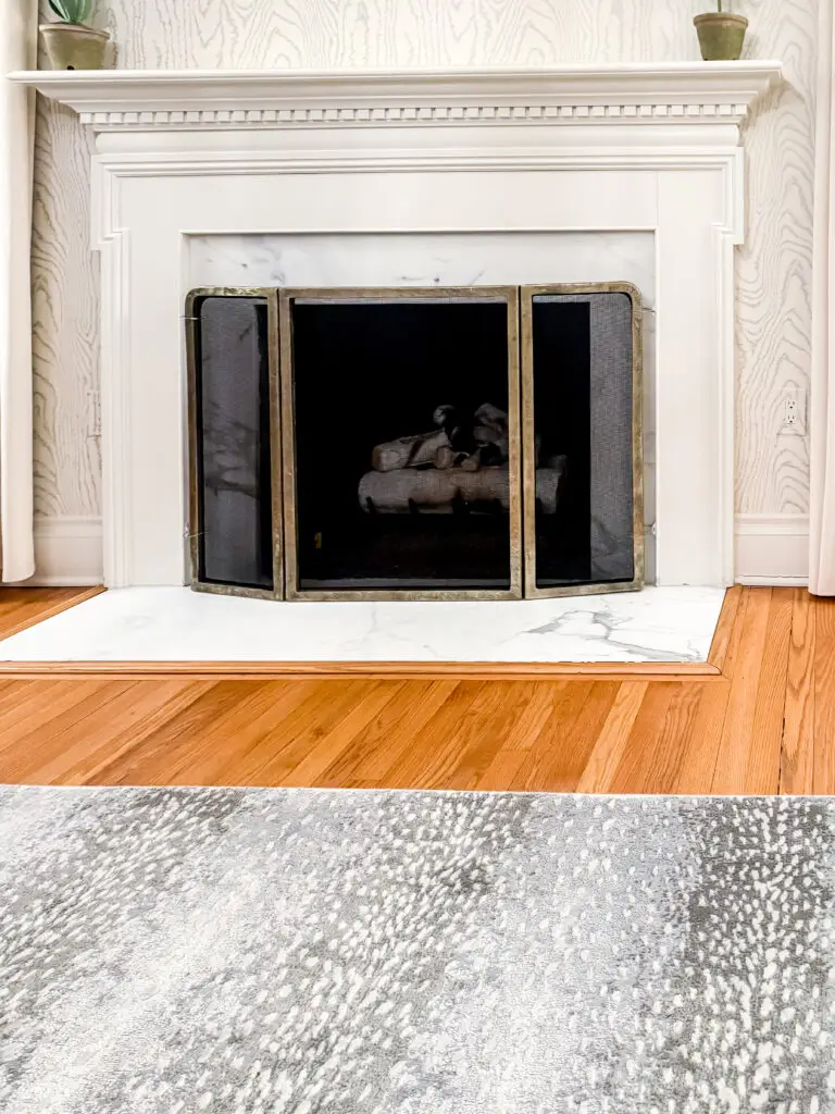 Fireplace safety screen secured across a marble fireplace in a palisades, dc living room