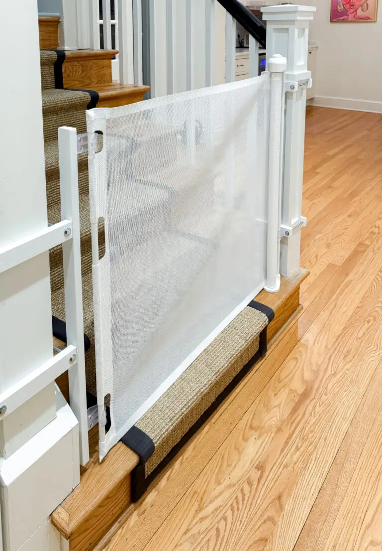 Close-up of a white retractable gate and its mount on a square newel post in a washington, dc home