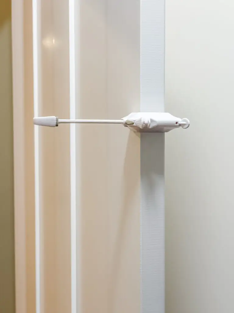 Door wing holding the door open just wide enough for the cats to reach the litter box while keeping the baby out