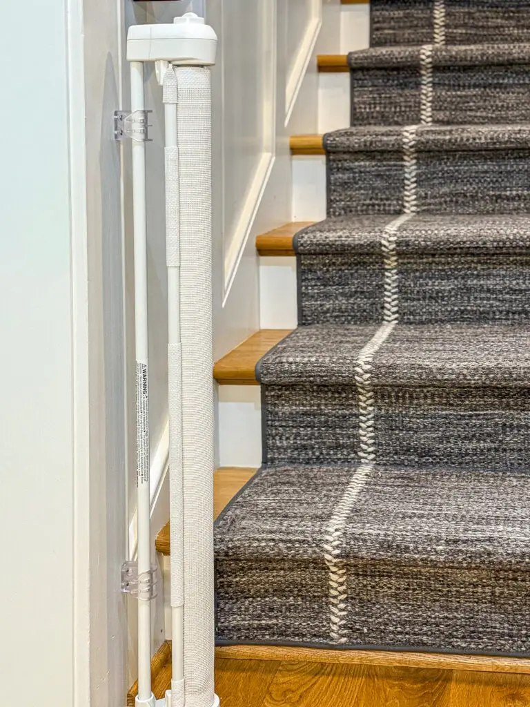 White retractable gate post mounted beside the main-floor stairs