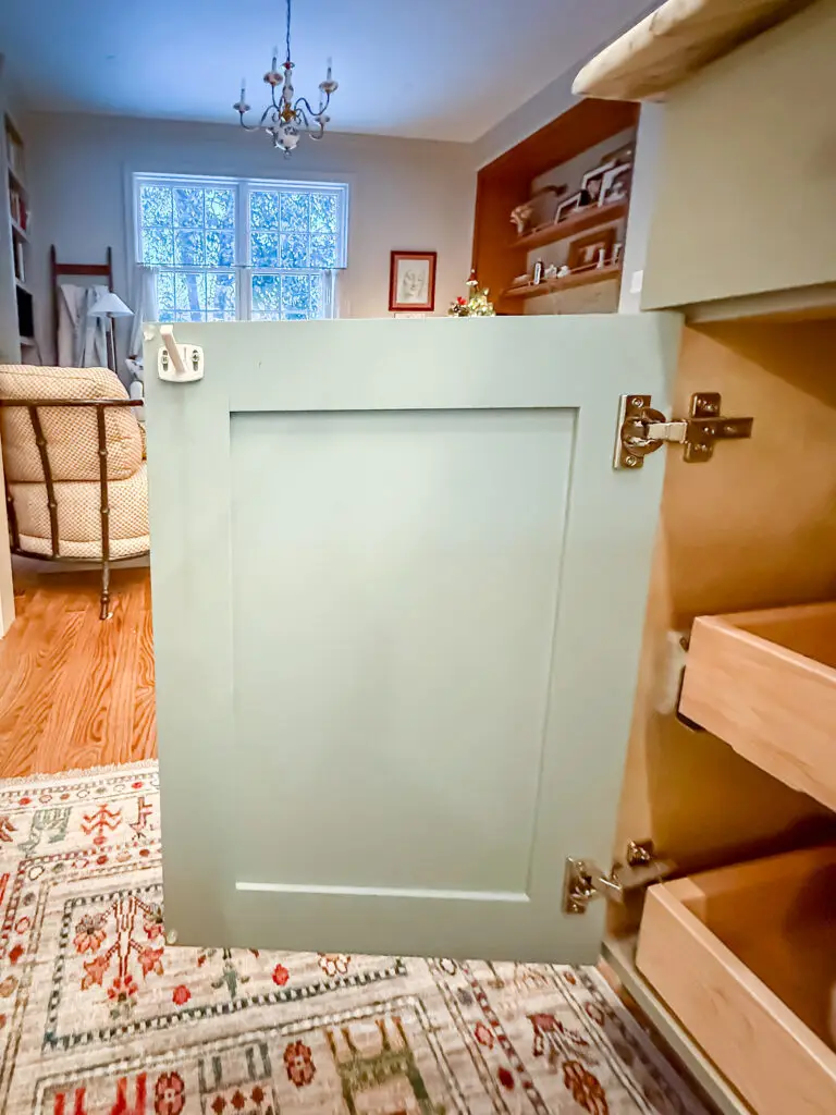 Cabinet latch installed inside a painted kitchen cabinet door in a dc rowhouse