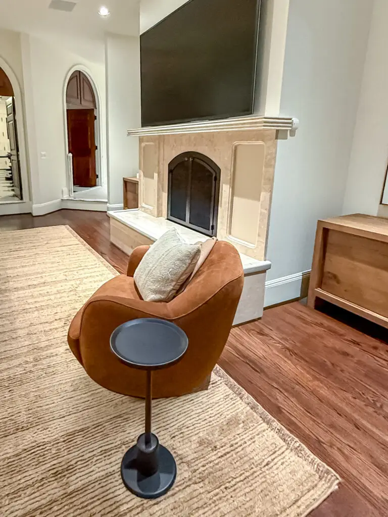Family room with an arched stone fireplace, padded hearth edge, and wall-mounted tv
