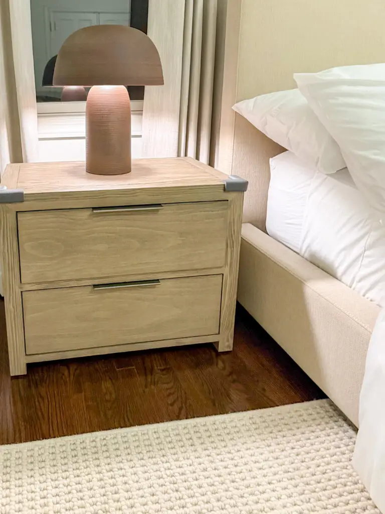 Nightstand with corner cushions on its low corners, anchored with furniture straps, in a maryland bedroom