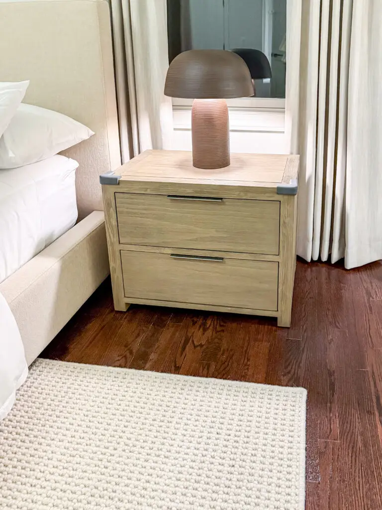 Anchored nightstand with corner cushions beside the bed